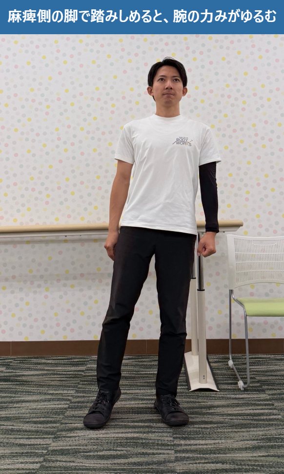 立って麻痺側の脚で床を踏みしめると、腕の力みがゆるむ